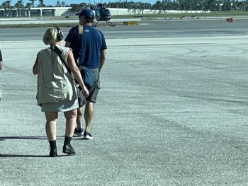 Two journalists, seen from the back, on a tarmac