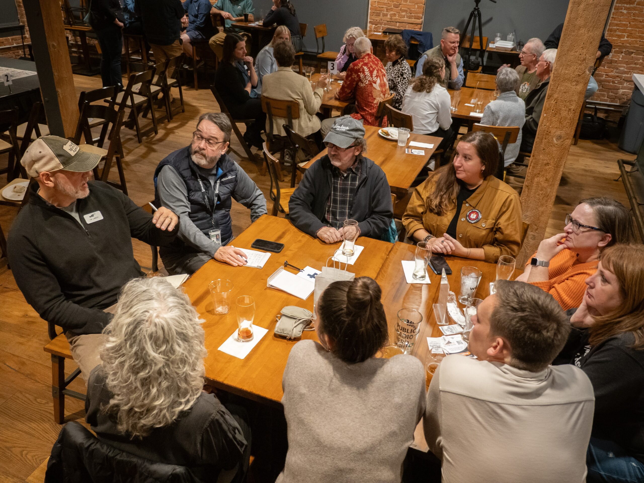 A group of people talk at a brewery