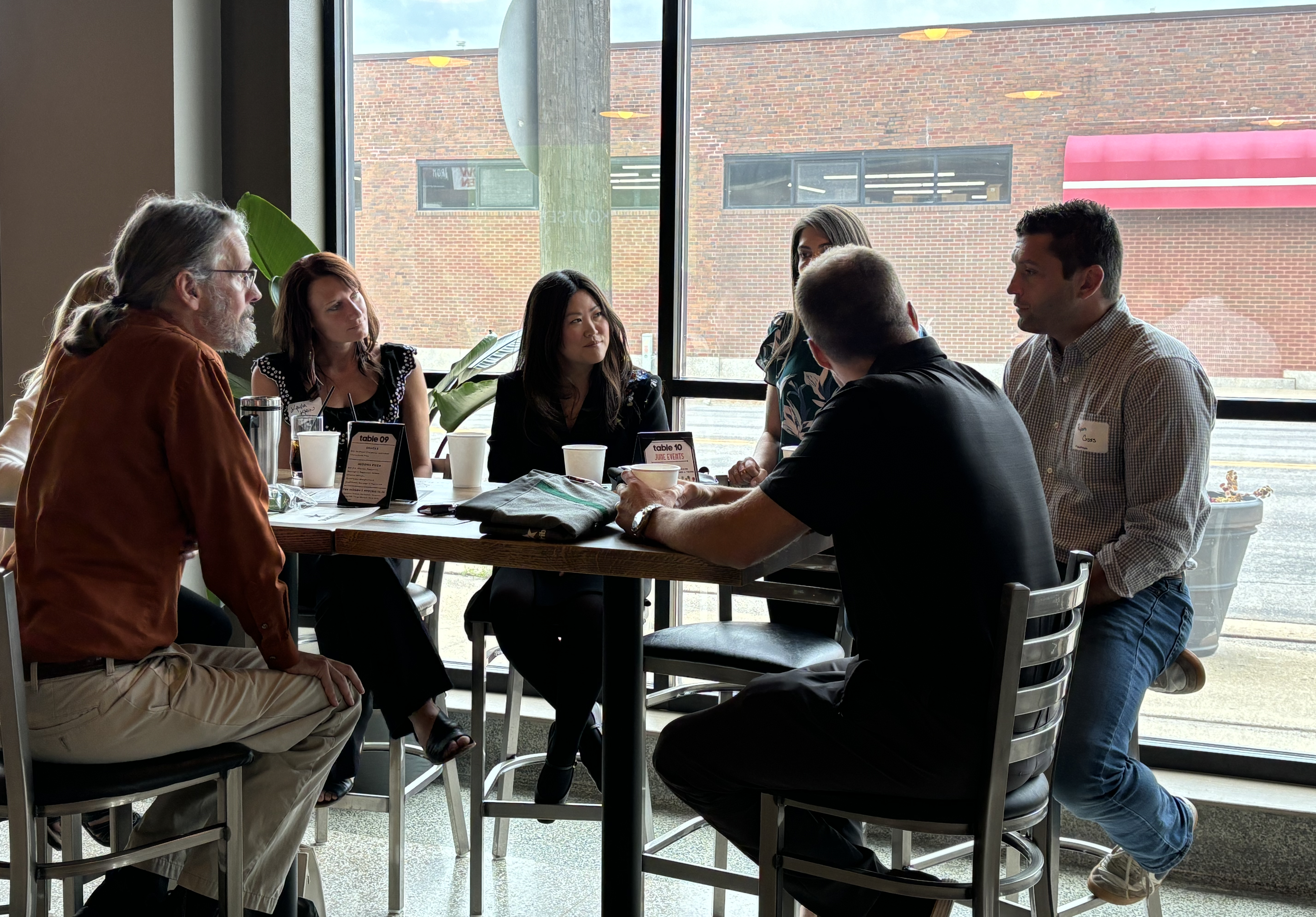 A group of adults sit around a table having a discussion