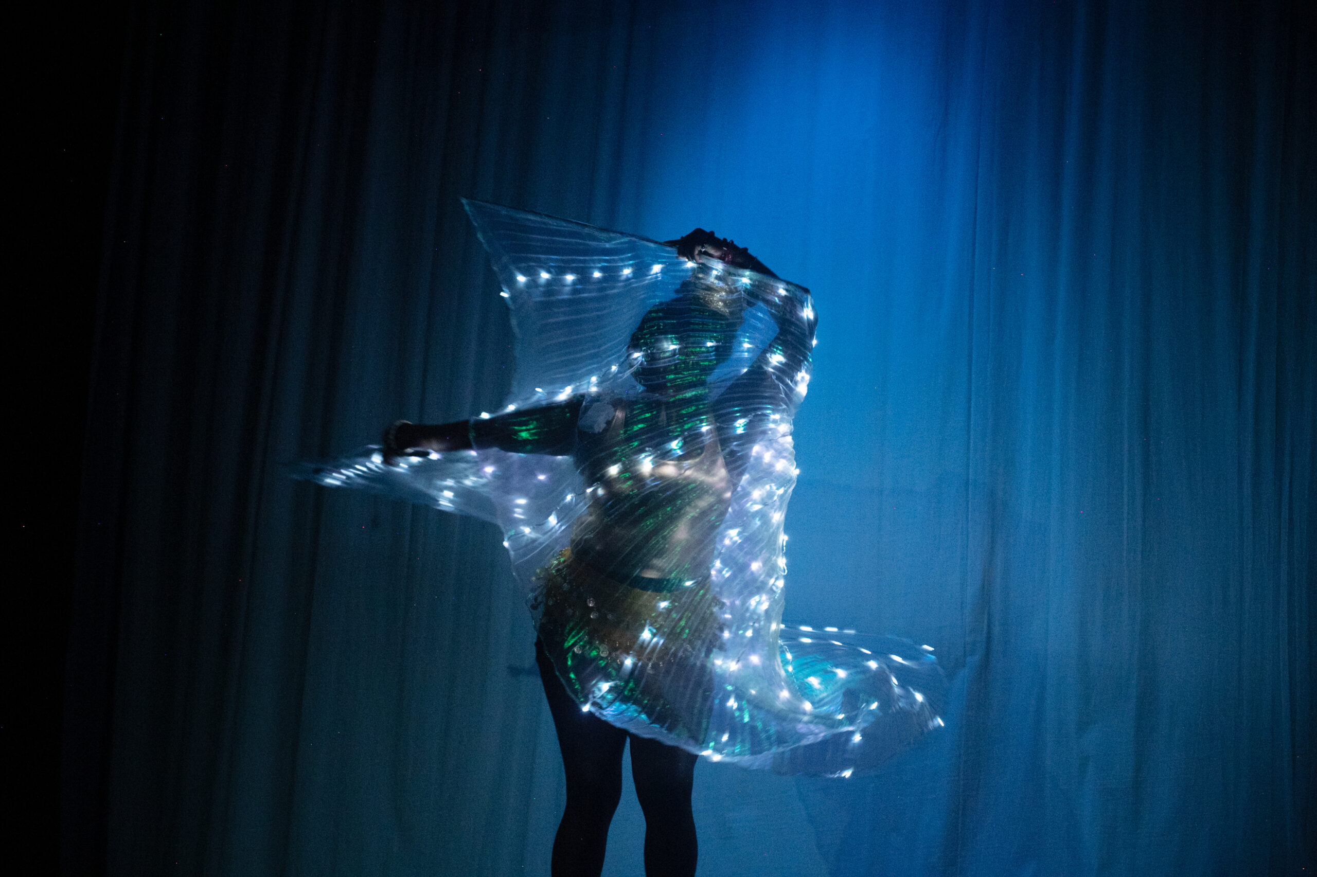 A woman with a lighted shawl dances