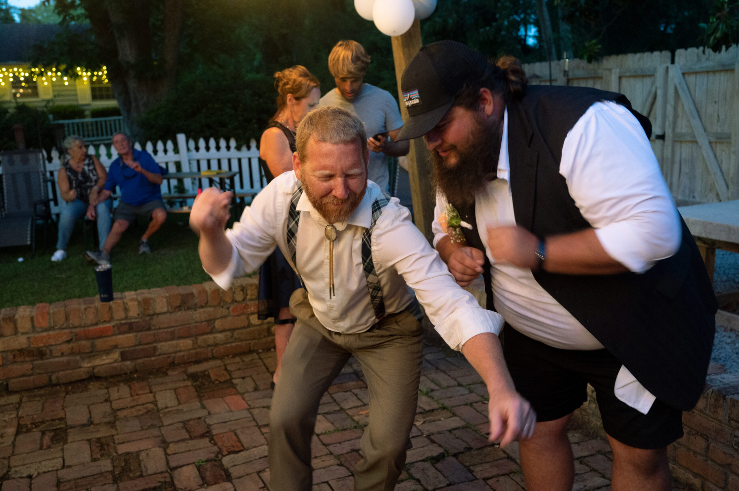 Two men dance on a patio