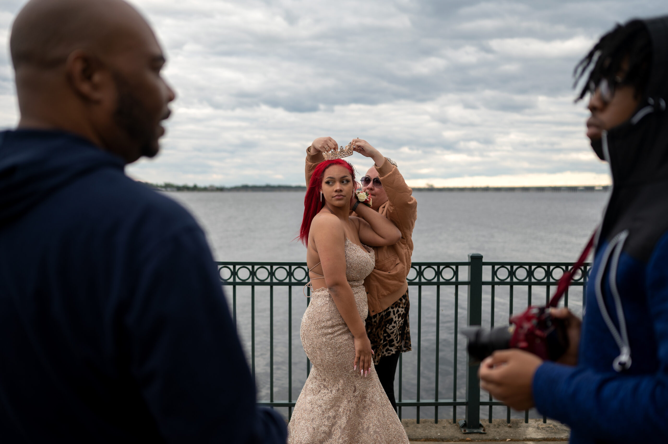 A woman puts a tiara on a girl in a bedazzled dress